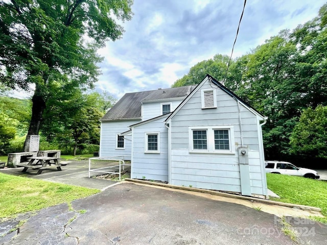 rear view of house featuring a yard and a patio area