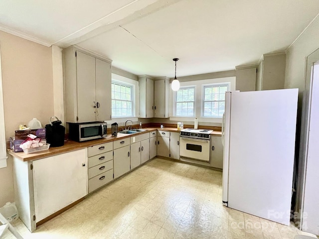 kitchen featuring sink, hanging light fixtures, wood counters, crown molding, and white appliances