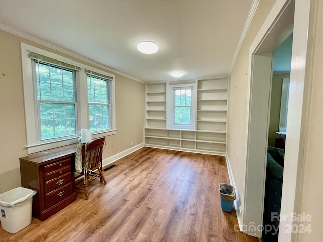 office area featuring light hardwood / wood-style floors, built in features, and ornamental molding