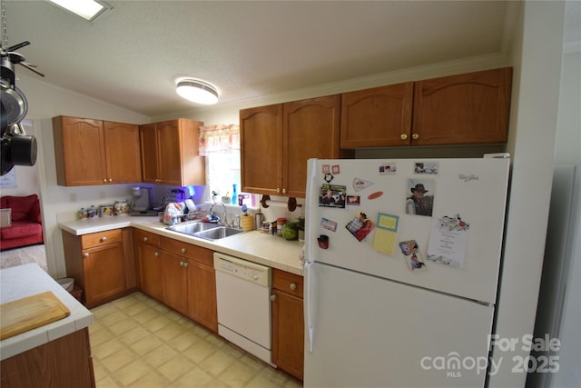 kitchen with lofted ceiling, white appliances, sink, ceiling fan, and a textured ceiling