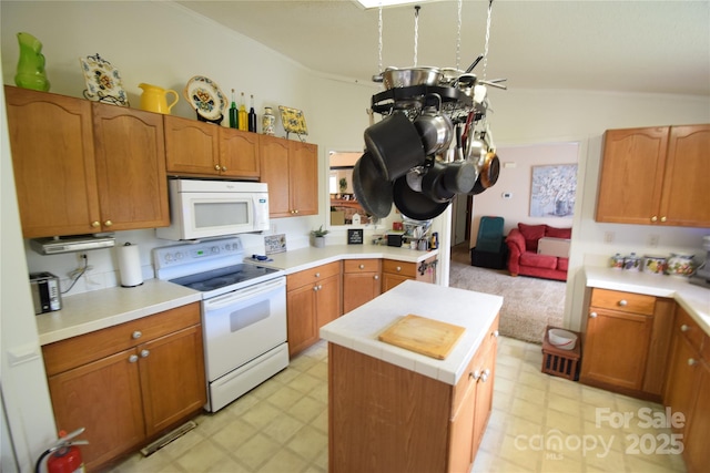 kitchen featuring a center island, white appliances, and vaulted ceiling