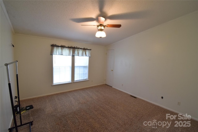 carpeted spare room with a textured ceiling and ceiling fan