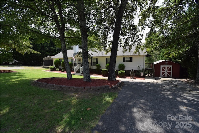 ranch-style home with a storage shed and a front yard