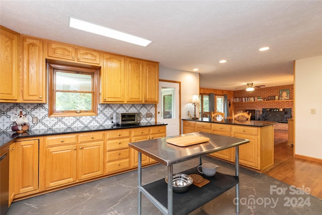 kitchen featuring a healthy amount of sunlight, backsplash, ceiling fan, and dark hardwood / wood-style floors