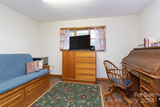 home office with a textured ceiling and hardwood / wood-style floors