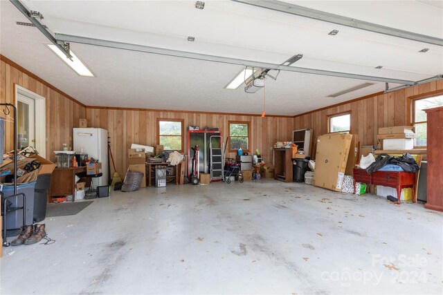 garage with white refrigerator and wooden walls