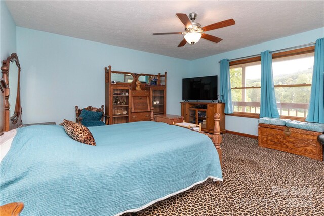 bedroom with ceiling fan, carpet, and a textured ceiling