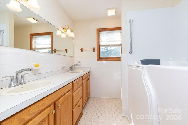 bathroom featuring double vanity, tile walls, tile patterned flooring, and decorative backsplash