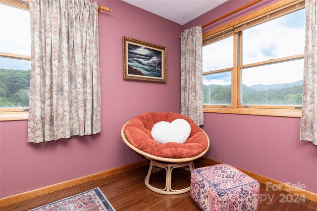 sitting room with a wealth of natural light and hardwood / wood-style floors