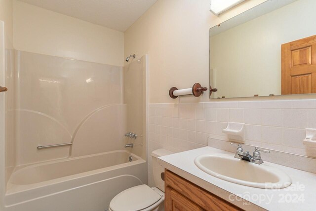 full bathroom with toilet, shower / bathing tub combination, tile walls, tasteful backsplash, and vanity