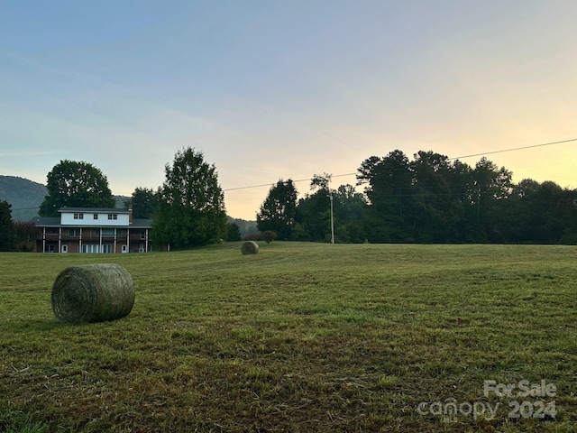 yard at dusk featuring a rural view