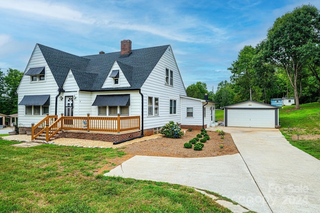 view of front of property with an outdoor structure, a garage, and a front lawn