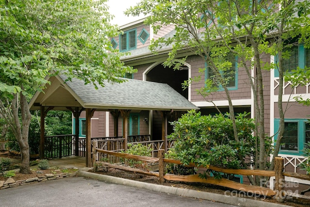 view of front facade with a porch and roof with shingles