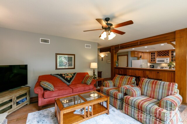 living room with light wood-type flooring and ceiling fan