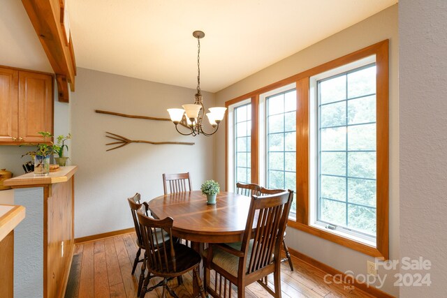 dining area featuring light hardwood / wood-style floors and an inviting chandelier