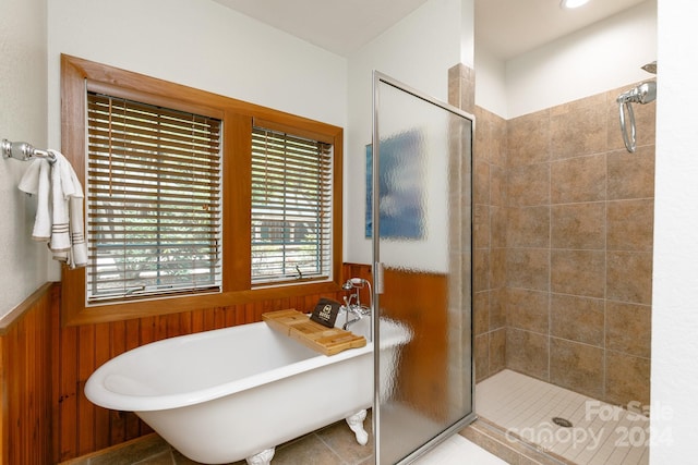 bathroom featuring a freestanding tub, a wainscoted wall, and wood walls