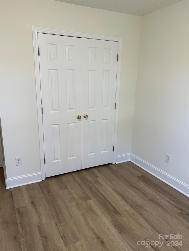 unfurnished bedroom with wood-type flooring and a closet