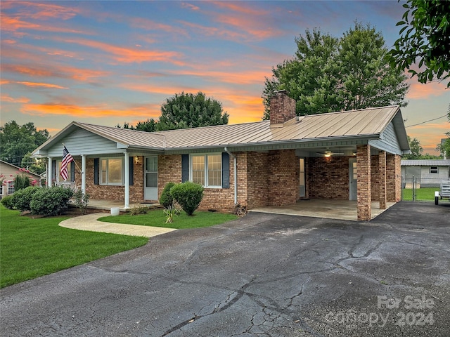 ranch-style home featuring a yard and a carport