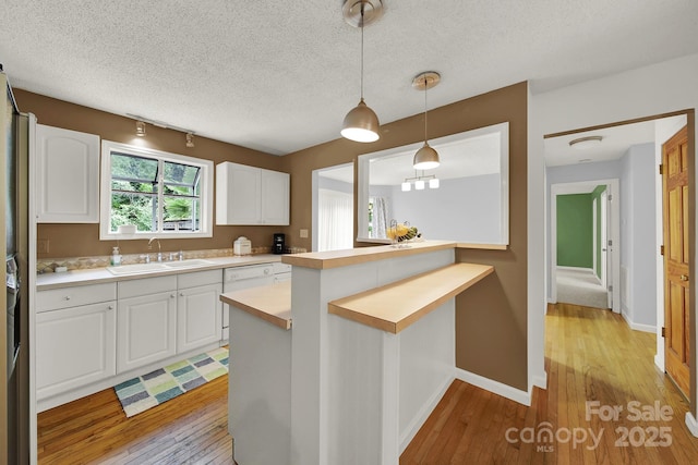 9143 Sadlers Ridge Rd, Fort Mill, SC 29707 - kitchen featuring a sink, light wood-style flooring, light countertops, white cabinets, and a textured ceiling