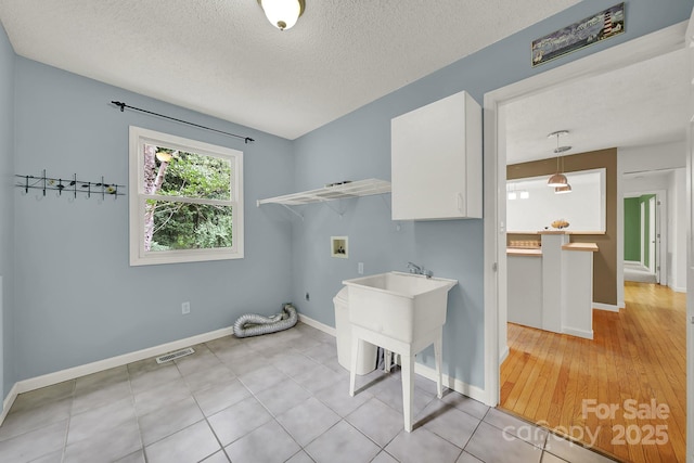 9143 Sadlers Ridge Rd, Fort Mill, SC 29707 - laundry area featuring washer hookup, cabinet space, a textured ceiling, baseboards, and electric dryer hookup