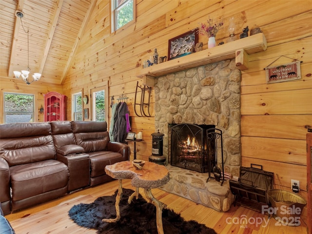 living room featuring a fireplace, wooden walls, wooden ceiling, and light wood-type flooring