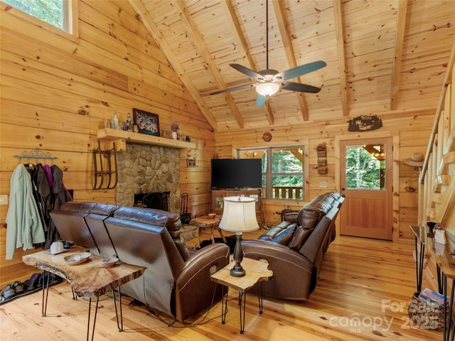 living room with a stone fireplace, wooden walls, light hardwood / wood-style floors, wooden ceiling, and beam ceiling