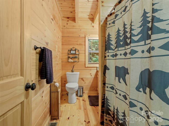 bathroom featuring wooden walls, wooden ceiling, beamed ceiling, and wood-type flooring