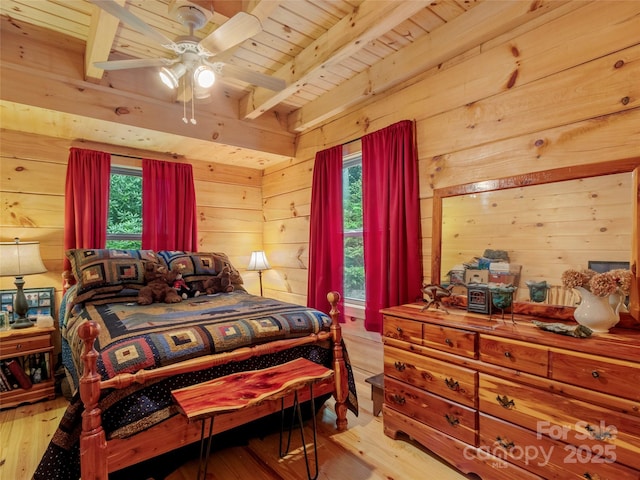 bedroom with wood walls, wooden ceiling, light wood-type flooring, ceiling fan, and beam ceiling