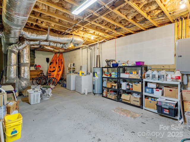 basement featuring washer and clothes dryer, electric panel, and electric water heater