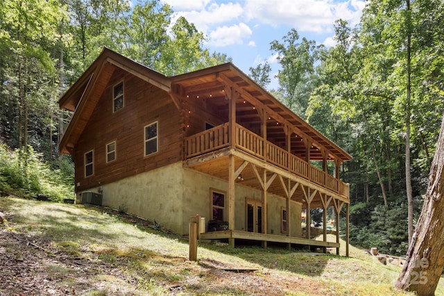 back of property with central AC unit and a deck