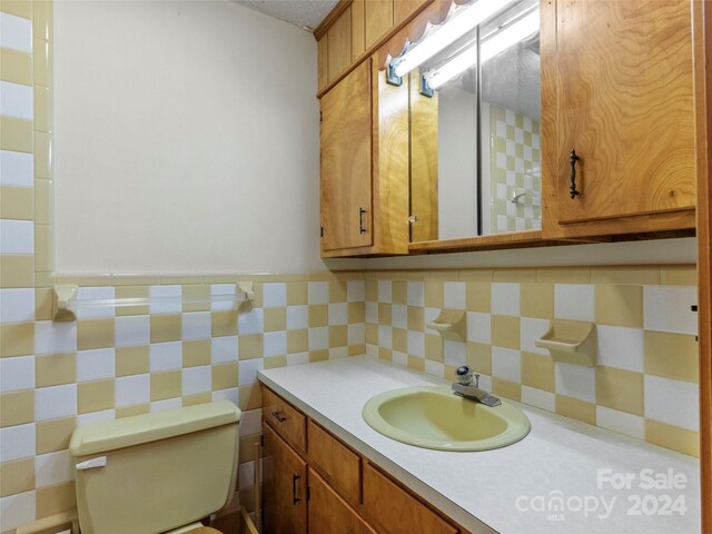 bathroom with backsplash, toilet, and vanity