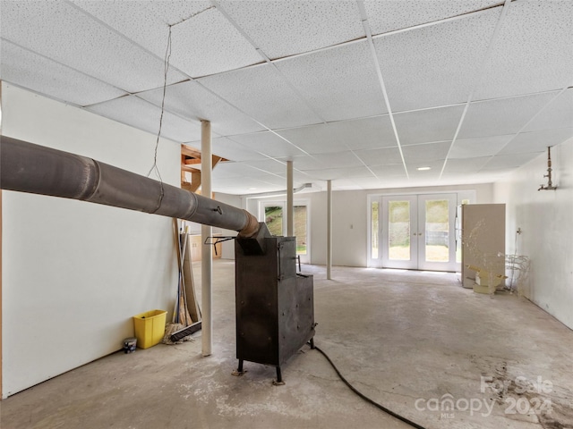 interior space with a drop ceiling, concrete floors, and french doors