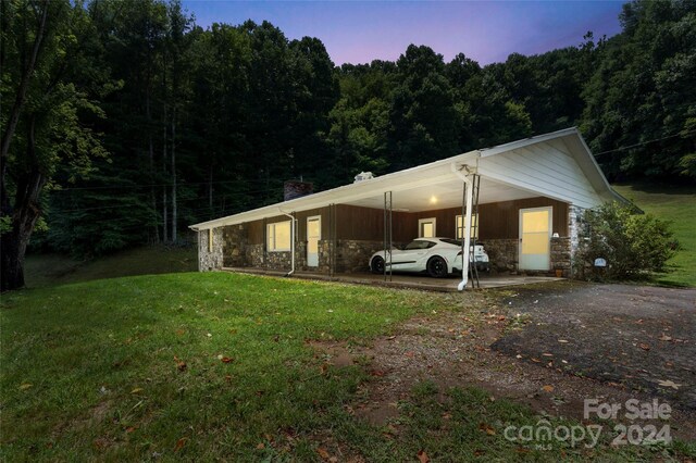 exterior space with a carport and a yard