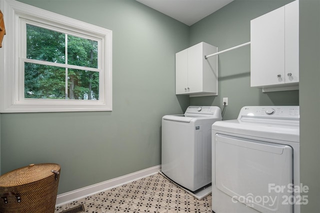 laundry area with washer and dryer and cabinets