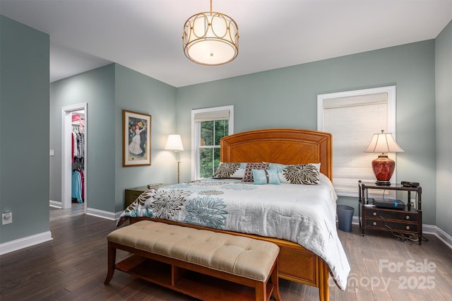 bedroom featuring dark hardwood / wood-style floors, a walk in closet, and a closet