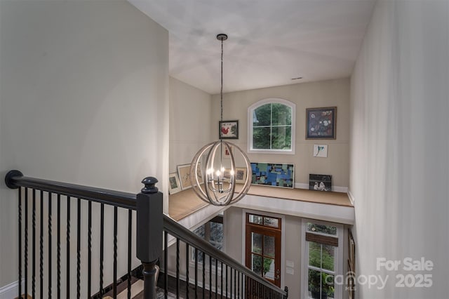 staircase featuring an inviting chandelier