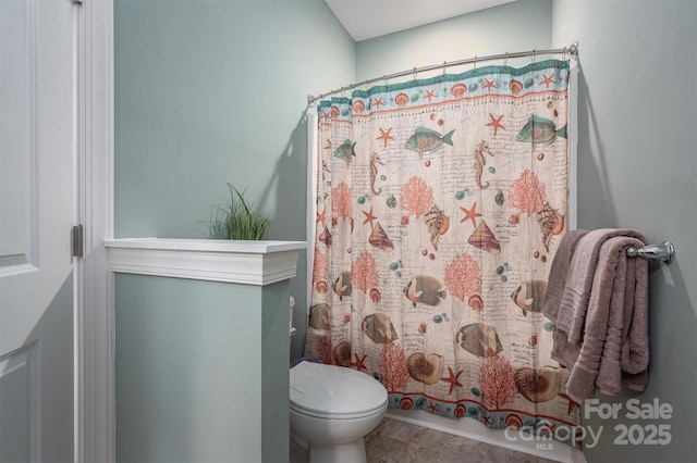 bathroom featuring a shower with curtain and toilet