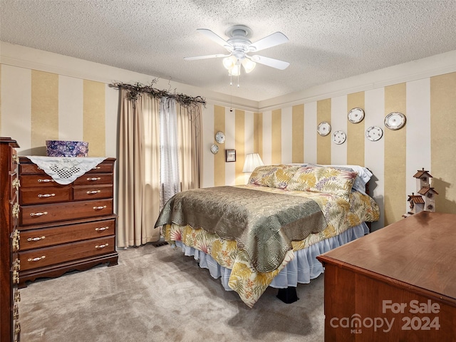 carpeted bedroom with ceiling fan and a textured ceiling