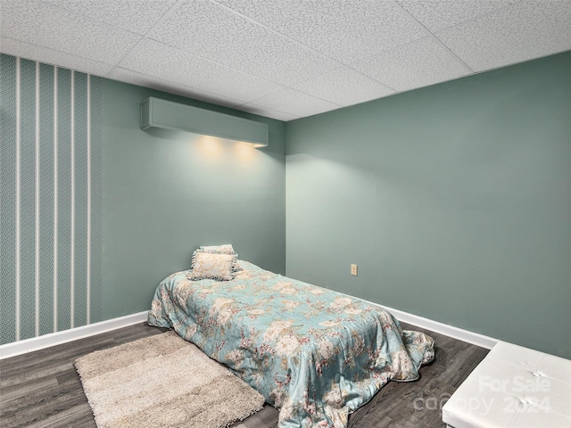 bedroom with dark hardwood / wood-style flooring and a drop ceiling