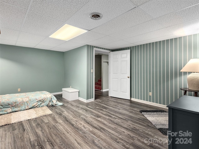 bedroom featuring dark hardwood / wood-style flooring and a drop ceiling