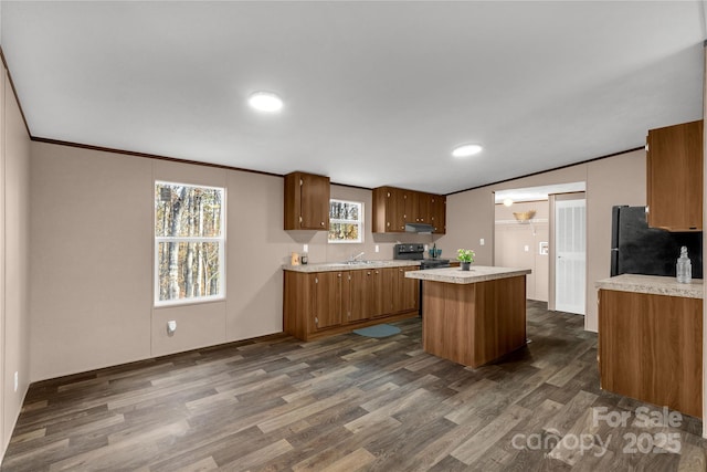 kitchen featuring ornamental molding, dark wood-type flooring, sink, black appliances, and a kitchen island