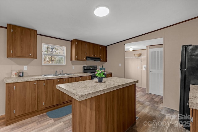 kitchen with black appliances, crown molding, sink, light hardwood / wood-style flooring, and a kitchen island