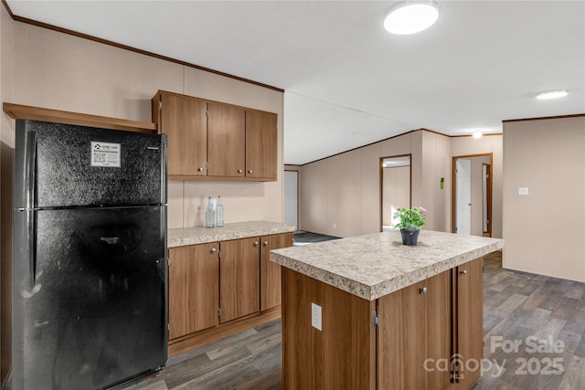 kitchen featuring black fridge, a center island, and dark wood-type flooring