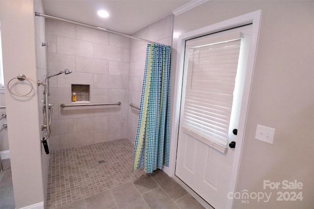 bathroom with tiled shower and tile patterned floors