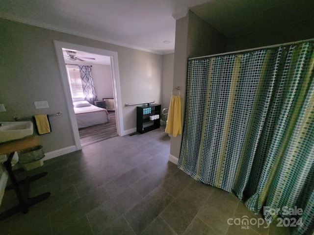 ensuite bathroom featuring crown molding, a sink, connected bathroom, a shower with curtain, and baseboards