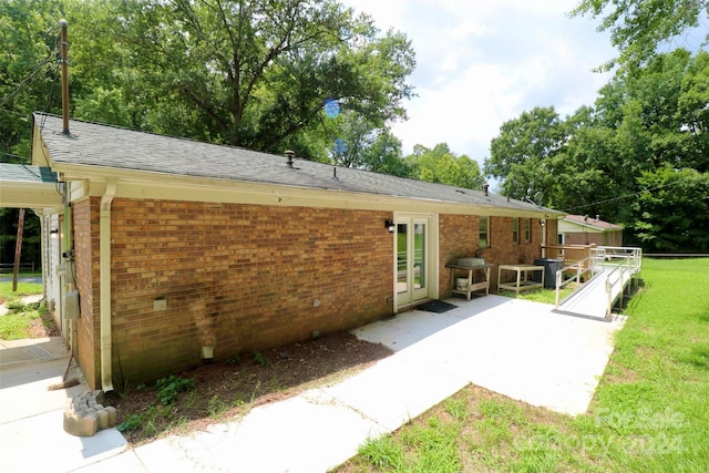 back of house with brick siding, a yard, a patio area, and fence