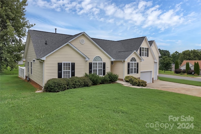 view of front of home with a front yard and a garage