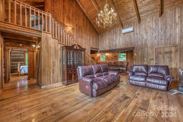 living room featuring wooden walls, high vaulted ceiling, and hardwood / wood-style floors