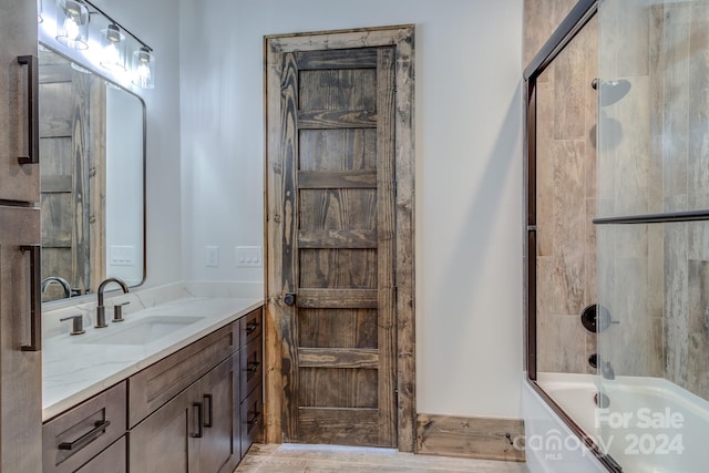 bathroom featuring shower / bath combination with glass door, wood-type flooring, and vanity