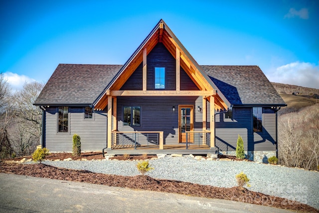 view of front of home featuring a shingled roof and covered porch